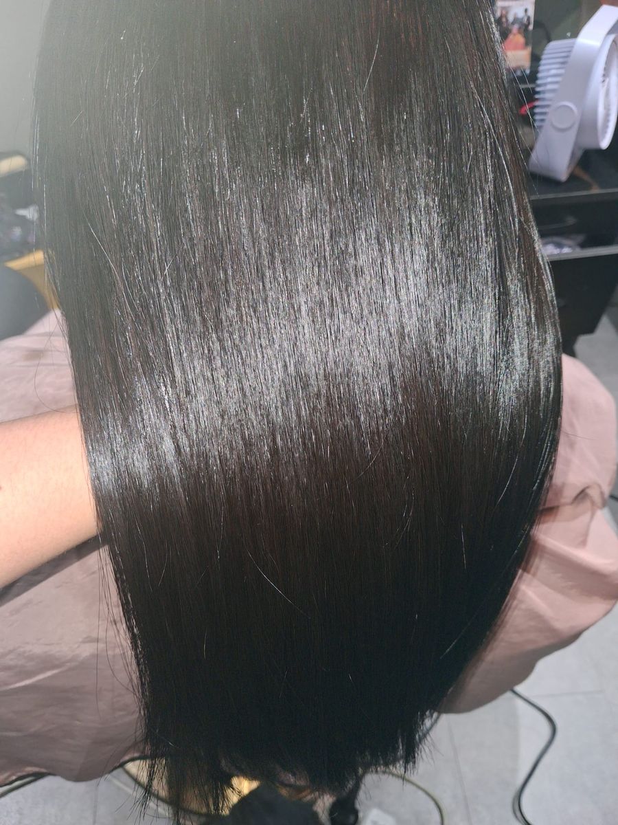 Close-up of sleek, glass-like dark hair after keratin smoothing