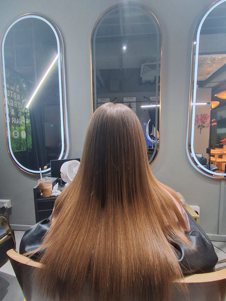 Long, straight light-brown hair with warm caramel ends after keratin
